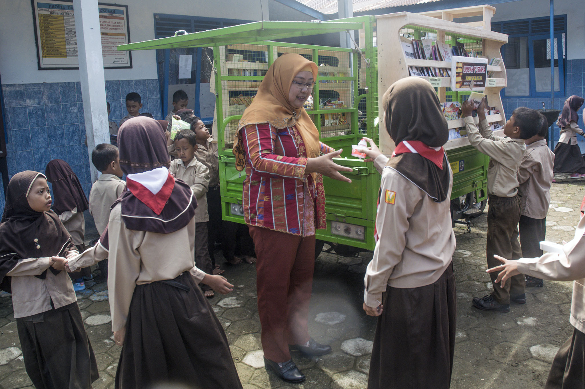 Para siswa menyetorkan sampah plastik sebagai syarat meminjam buku. Foto : L Darmawan
